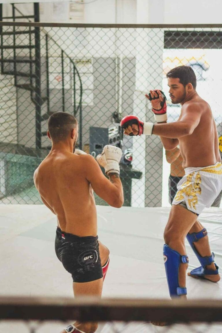 Two Muay Thai students sparring lightly in a training area while practicing timing and distance as part of Muay Thai fundamentals for beginners.