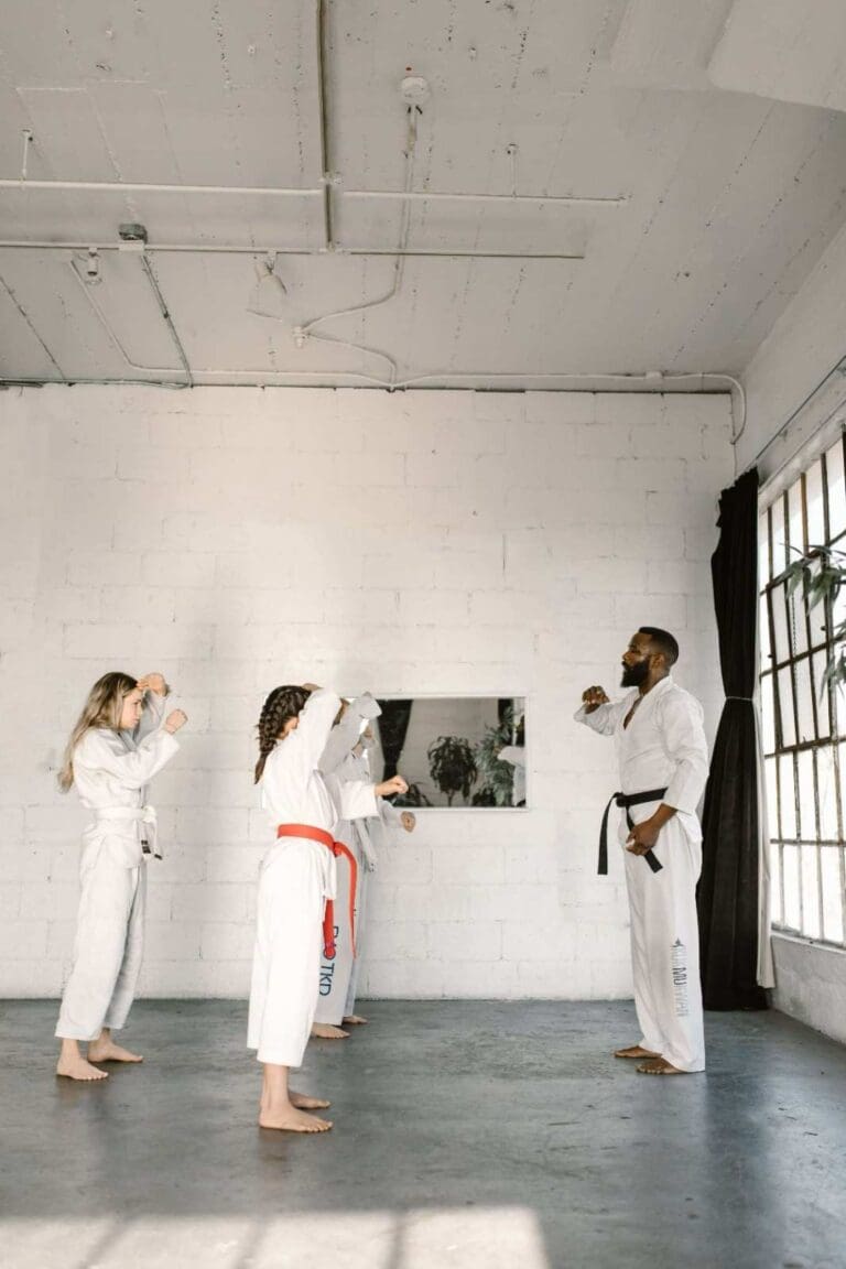 Taekwondo instructor demonstrating a defensive stance to students during a structured class for a Taekwondo training guide.