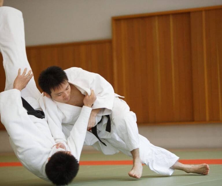 Brazilian Jiu Jitsu practitioner executing a sweep during live gi grappling practice demonstrating what is Brazilian Jiu Jitsu